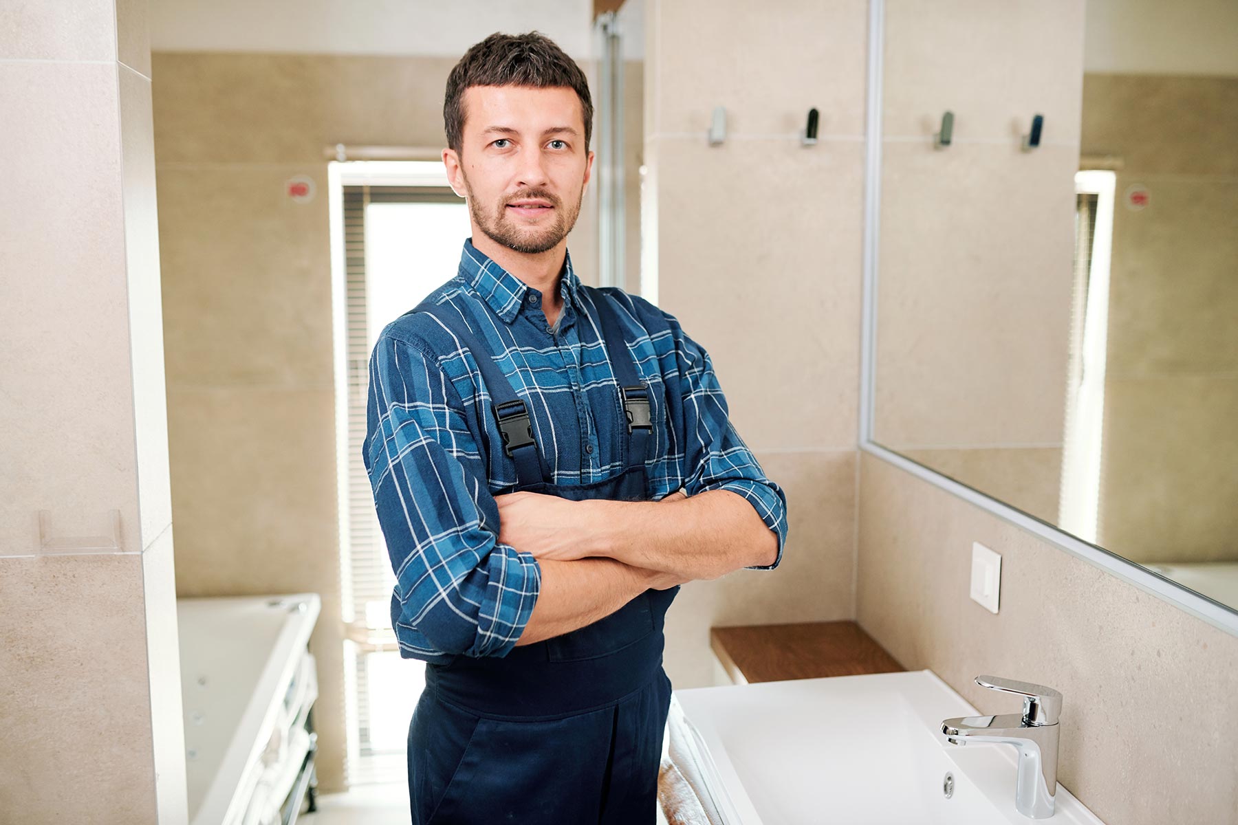 young-successful-plumber-in-workwear-standing-in-b-3P7U6YB.jpg